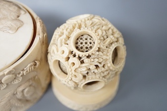 A late 19th century Chinese carved ivory concentric ball comprising seven reticulated spheres, with a small stand, and a Japanese carved ivory box (base missing), Meiji period, of cylindrical form, decorated with a black